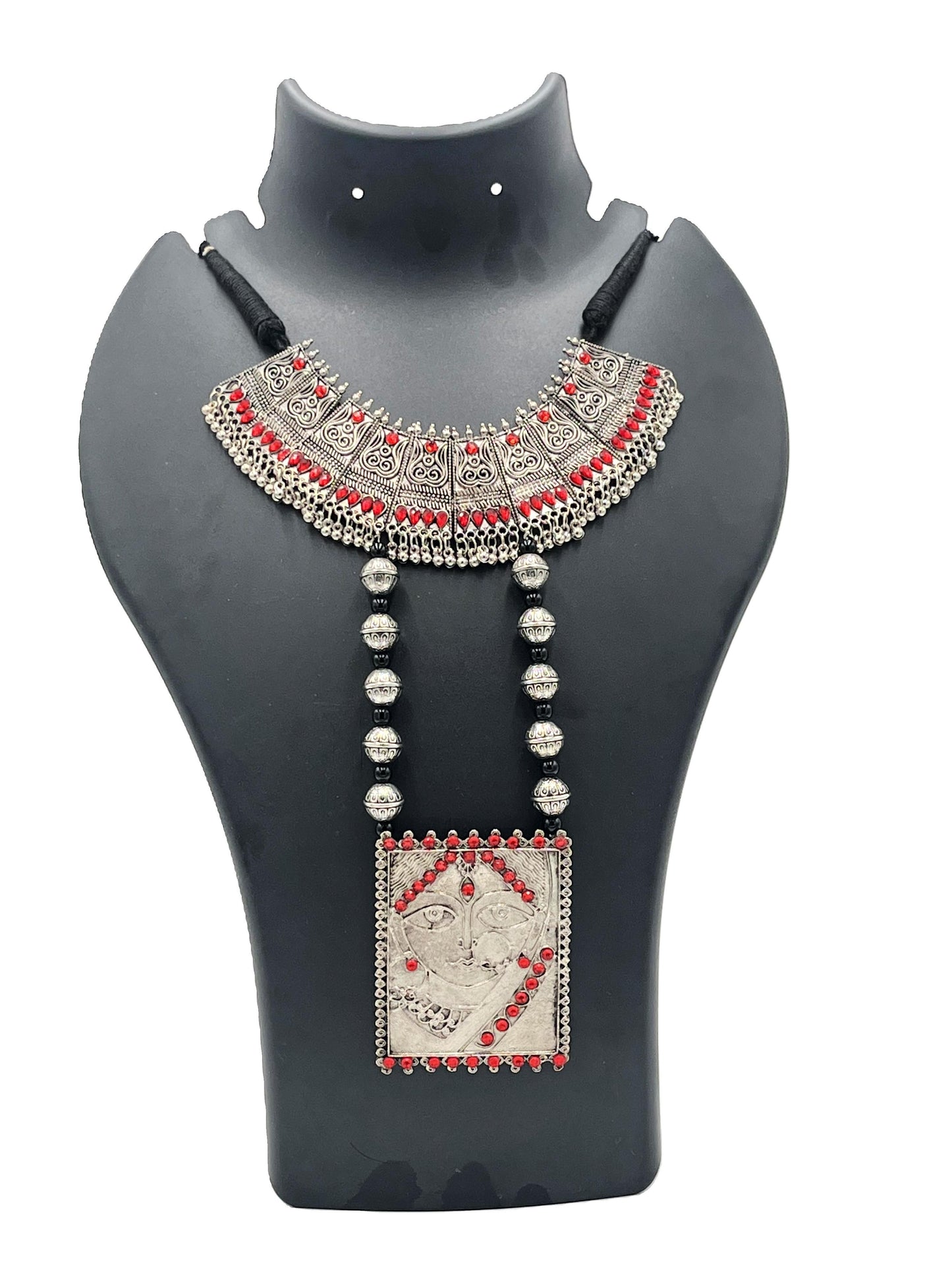 Decorative necklace with red and silver accents on a black mannequin bust.