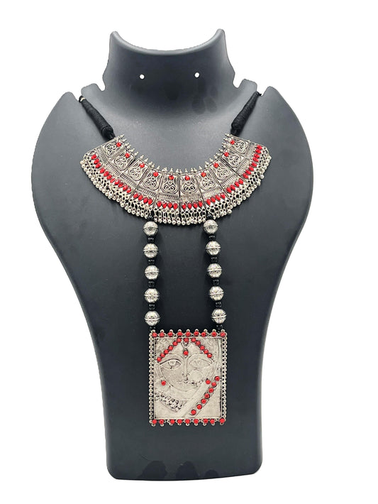 Decorative necklace with red and silver accents on a black mannequin bust.
