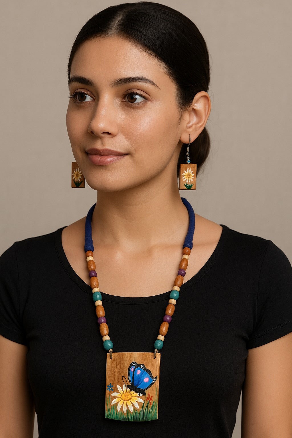 Woman wearing a Bamboo necklace with a butterfly pendant against a neutral background
