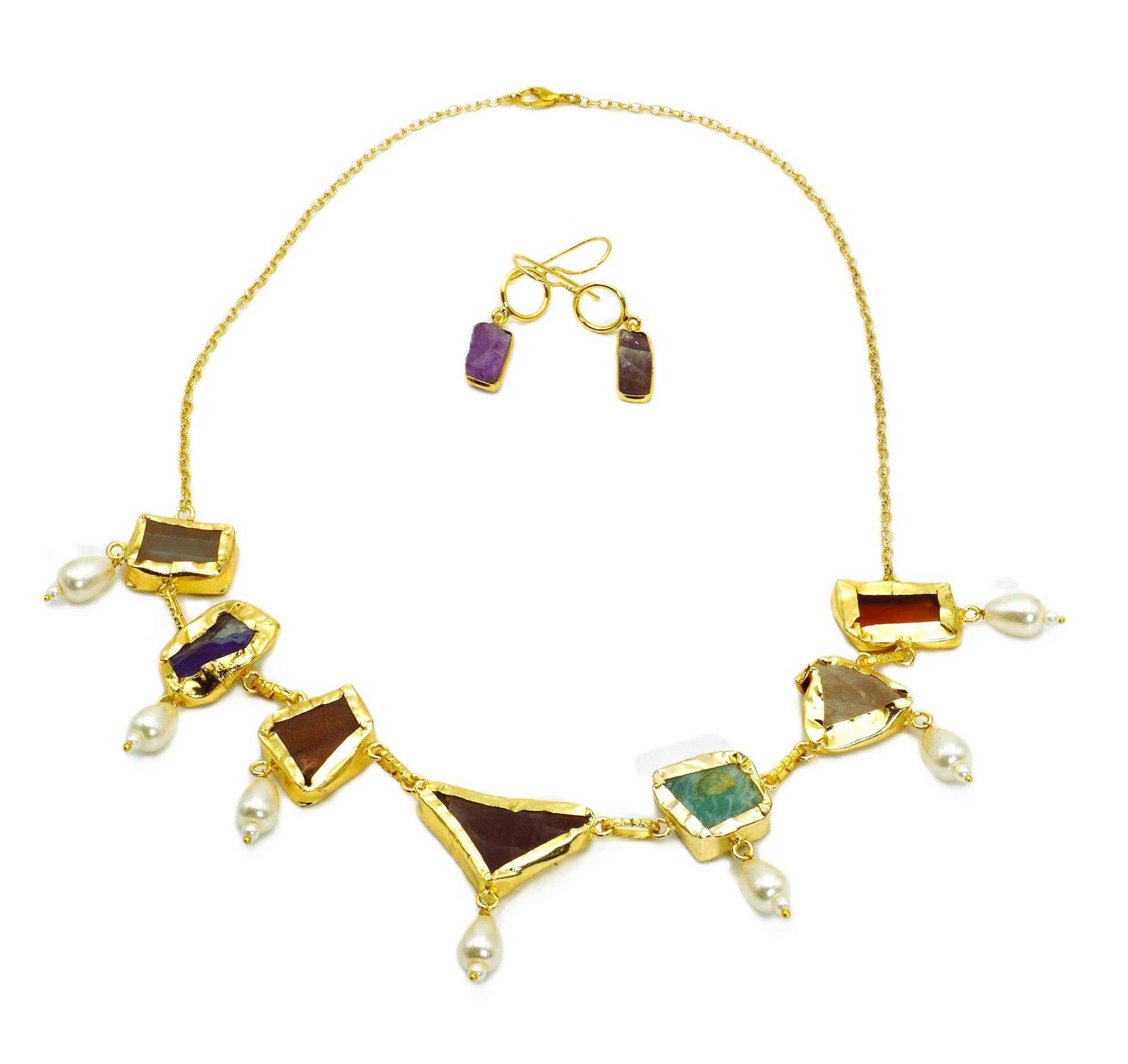 Gold necklace with gemstones and pearls on a white background