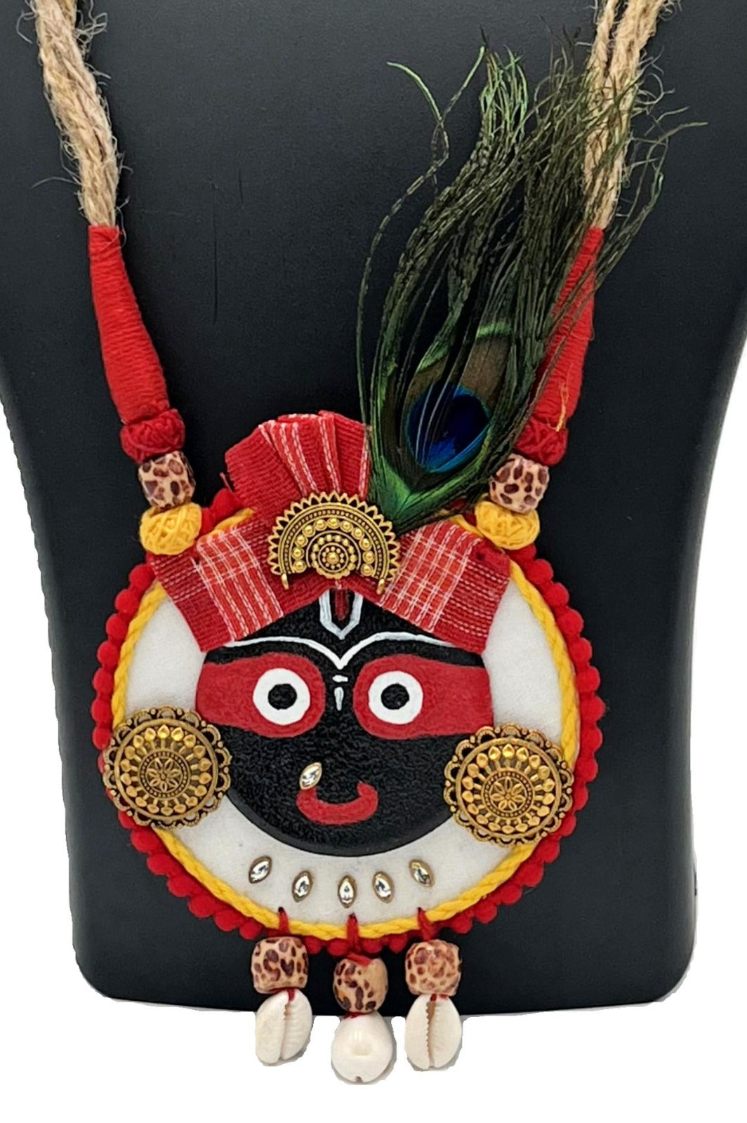 Close-up of Lord Jagannath pendant with red, gold & black detailing