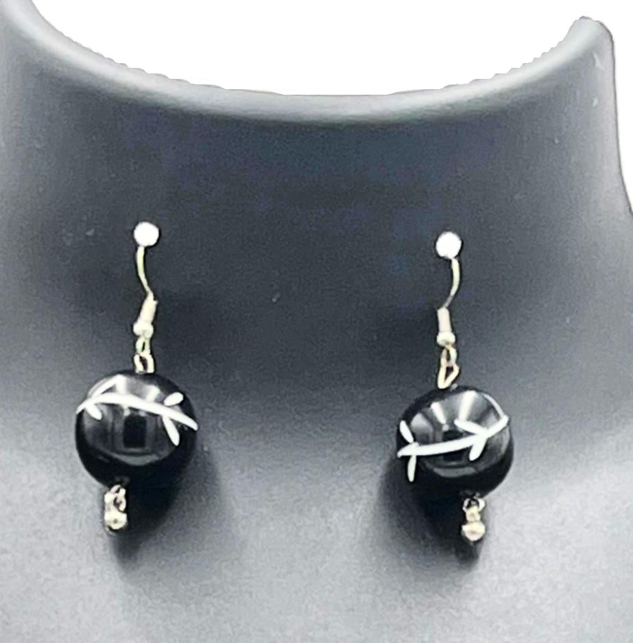 Close-up of black bead earrings on braided jute necklace – The Chakmak